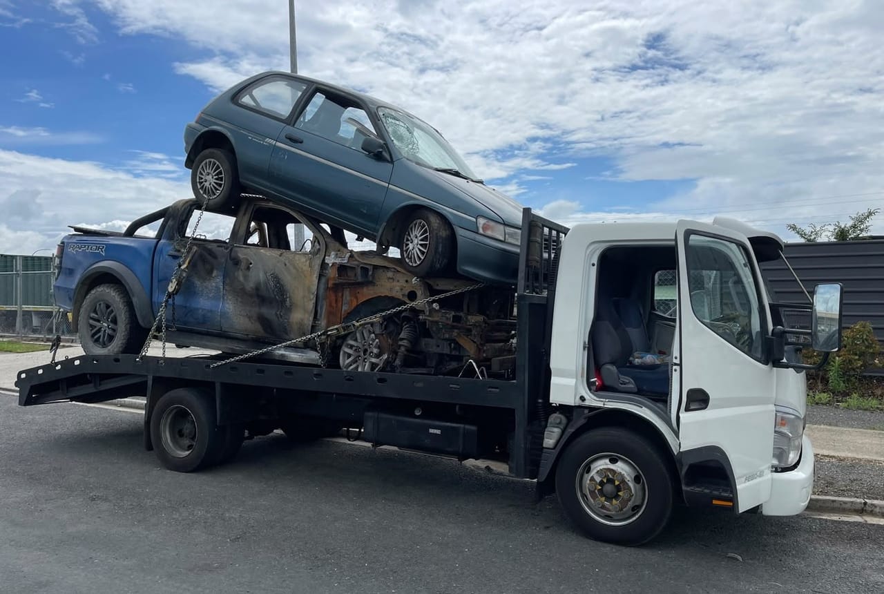 Flatbed truck loaded with scrap cars for removal in Palmerston North